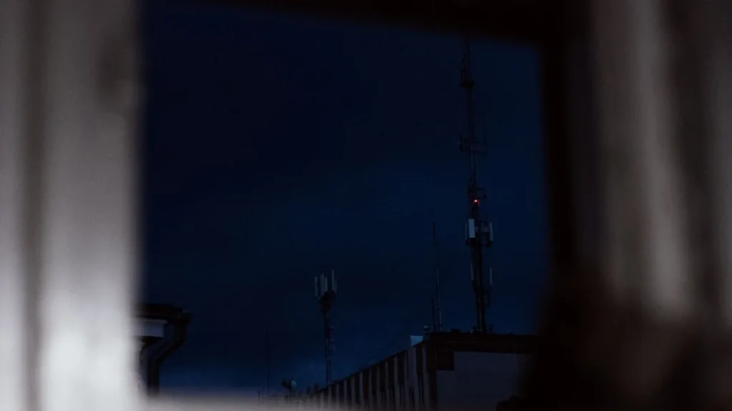 Antene de telecomunicații văzute noaptea printr-o fereastră